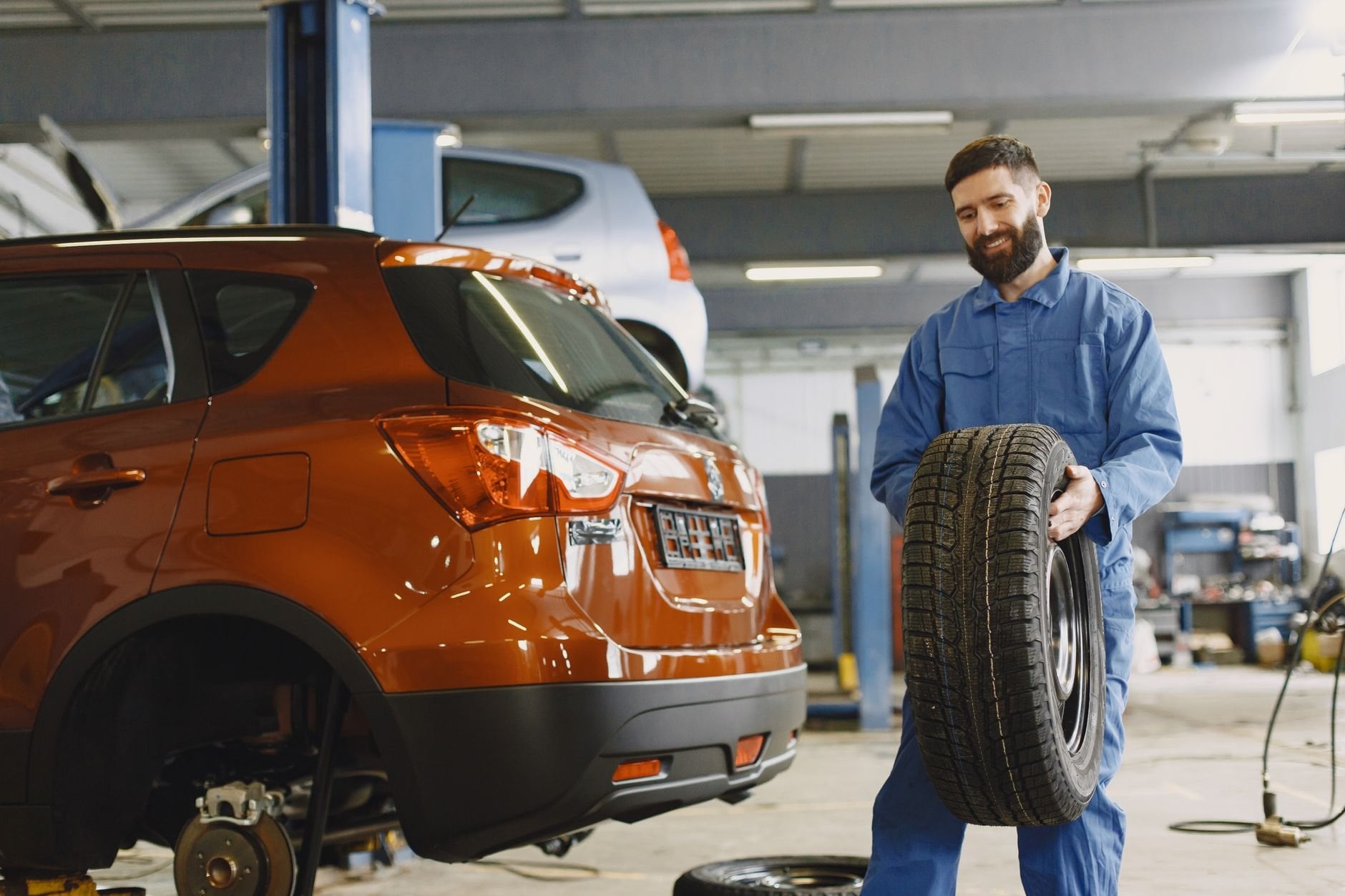 Mechanic handling a tire in an auto service shop